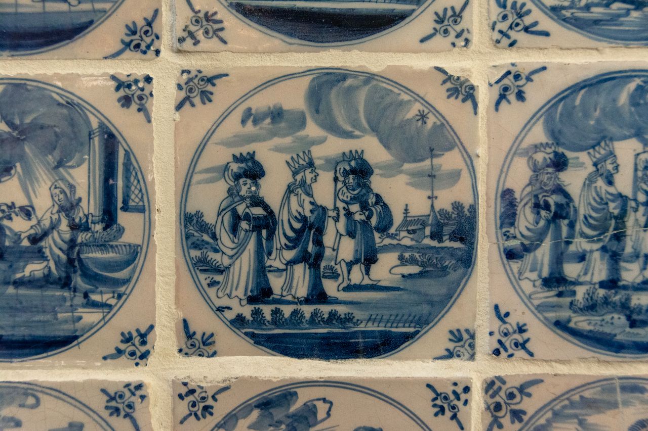 Intricately designed Delft blue tiles featuring historical scenes in classic style.